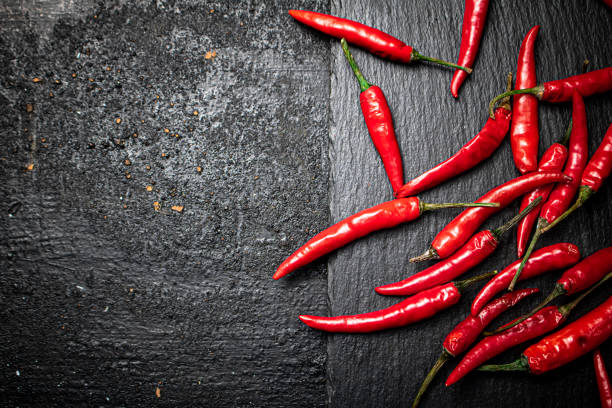istock Chili pepper pods on a stone board. 1374574926