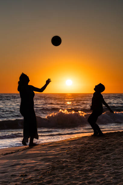 istock Mother and son playing with a ball on the beach at sunset 1374576536