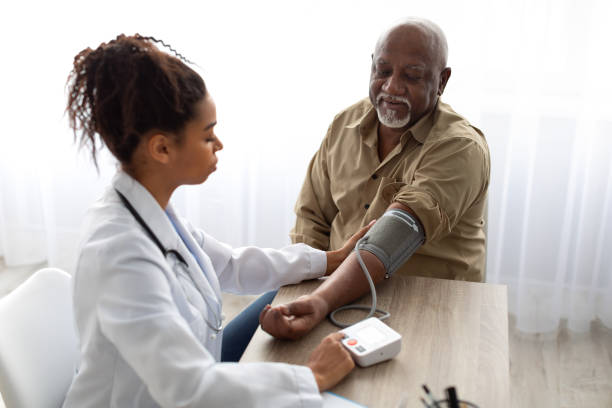doctora negra que comprueba la presión de medición en la mano del paciente - hipertension fotografías e imágenes de stock