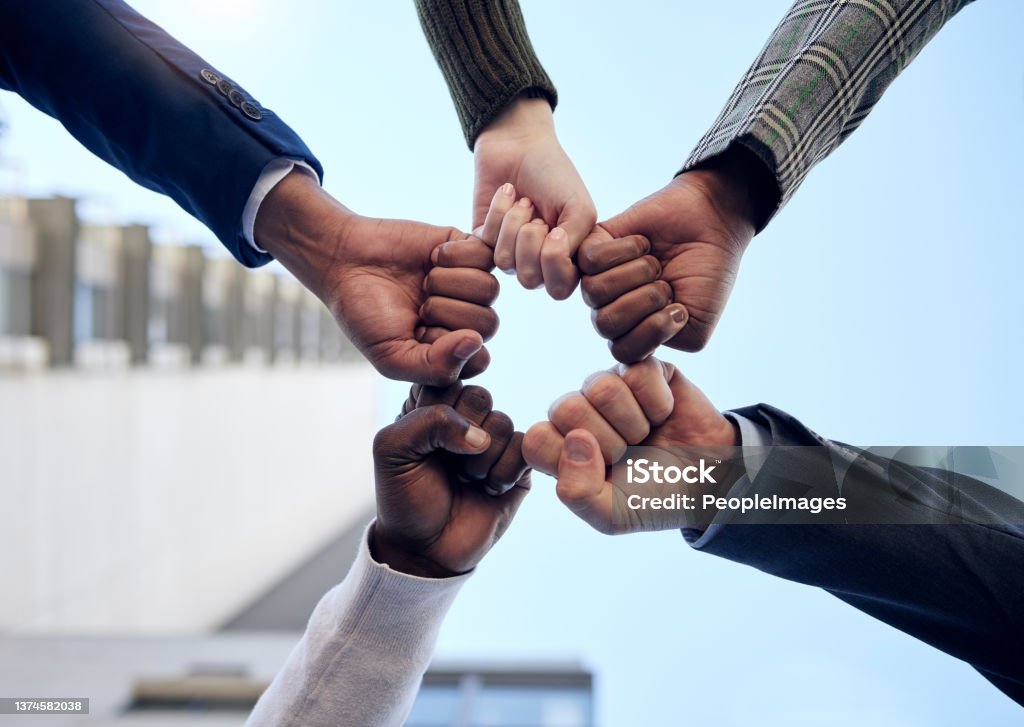 Shot of a group of unrecognizable businesspeople giving each other a high five outside Let's do this! Fist Bump Stock Photo