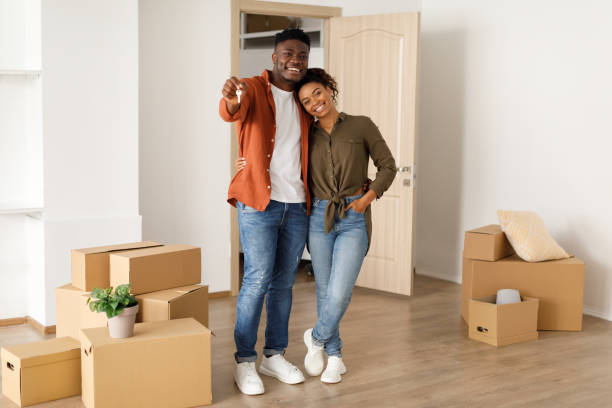 istock Happy African Spouses Showing Key Standing Among Moving Boxes Indoor 1374582603