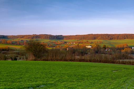 A spectacular show of colors during the sunrise in the rolling hills of the Netherlands, with views over the green meadows, the hills, valley and typical craftsmanship houses.