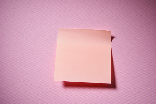 blank orange adhesive note on pink color background