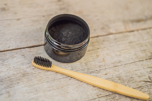 Activated charcoal powder for brushing and whitening teeth. Bamboo eco brush.