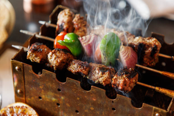 istock Shashlik and vegetables on skewer grilling on mini barbecue 1374641669