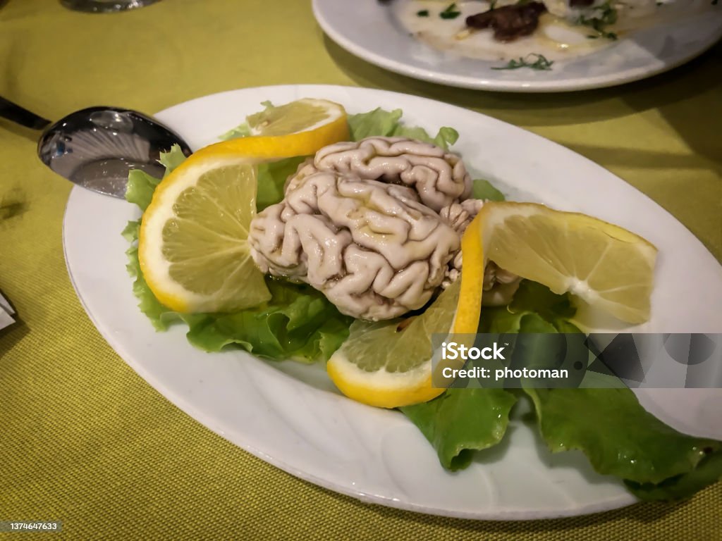 Cooked Brain Meze food cold starter with lemon slice Kebab Restaurant with traditional Eastern receipts. Mediterranean food culture. Gourmet foodie trip to Anatolia, Turkey as travel destination. Perfectly served local plates. Variety of delicious bites. Food background with large copy space. Brain Stock Photo