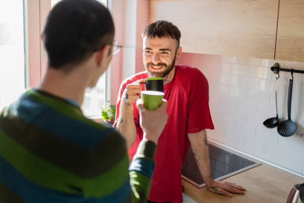 istock Young man having coffee with his partner at home and looking at him affectionately 1374649356