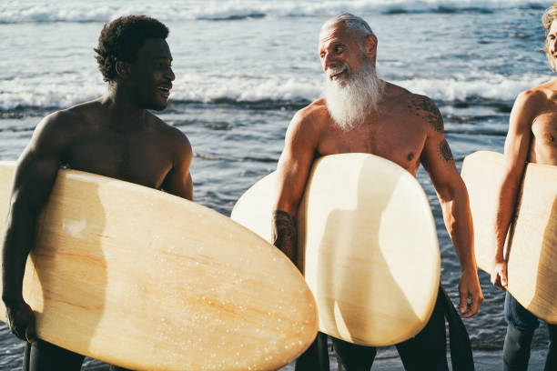 istock Multi generational surfer men having fun on the beach - Focus on senior man face 1374650364