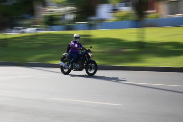 salvador, bahia, brazil - february 15, 2022: motorcyclist transiting with her motorcycle on a street in the city of Salvador.