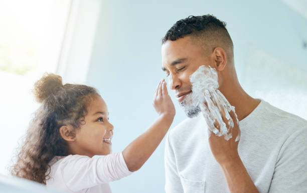 zdjęcie małej dziewczynki i jej ojca bawiących się kremem do golenia w łazience w domu - men shaving human face bathroom zdjęcia i obrazy z banku zdjęć