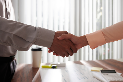 Business people shaking hands over table after successful meeting