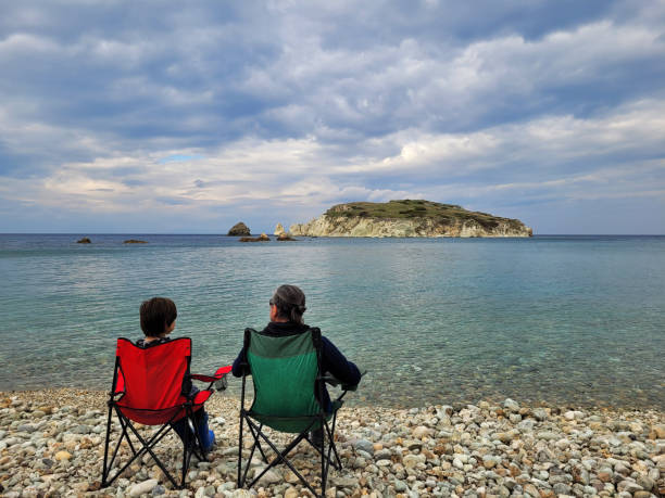 istock man is sitting on the beach with his son 1374699785