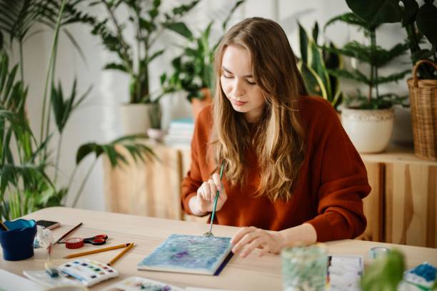istock Woman blends paint on an aquarelle drawing paper by using watercolour paint 1374728340