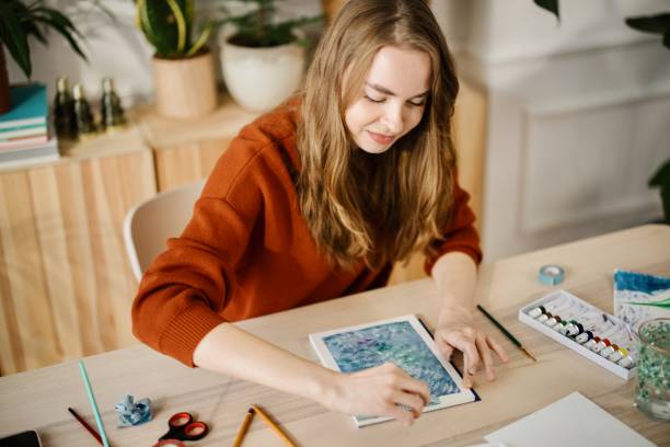 istock Woman blends paint on an aquarelle drawing paper by using watercolour paint 1374728343