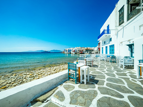 Tables and chairs of a tavern, on the sandy beach of Mavrouvouni