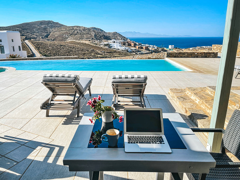Laptop on terrace with nice sea view, Elia, Mykonos island, Cyclades, Greece. Property released.