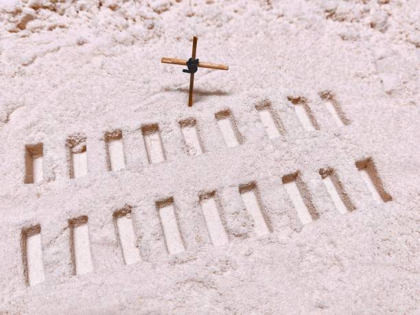 istock Wooden Cross with Graveyard Made From The Sand 1374748383