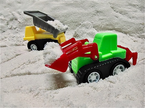 Yellow Toy Excavator, Bulldozer, Dozer or Crawler and Toy Dump Truck, or Dumper on Sand.