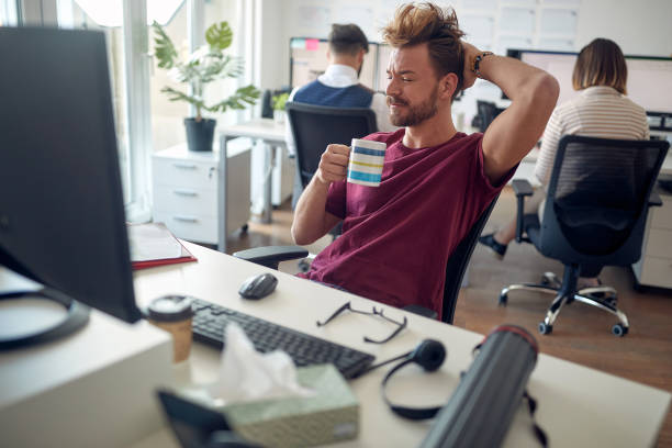 Designer relaxing with foot on the desk in a modern office