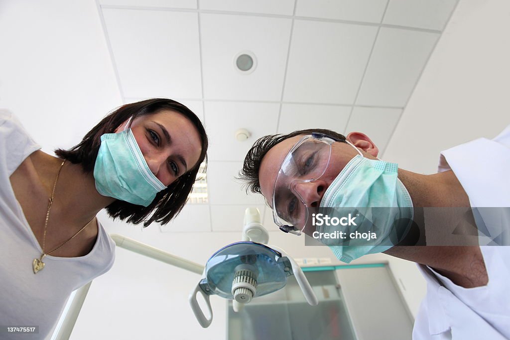 Dentista y su assistante sonriendo a la cámara. - Foto de stock de Adulto libre de derechos
