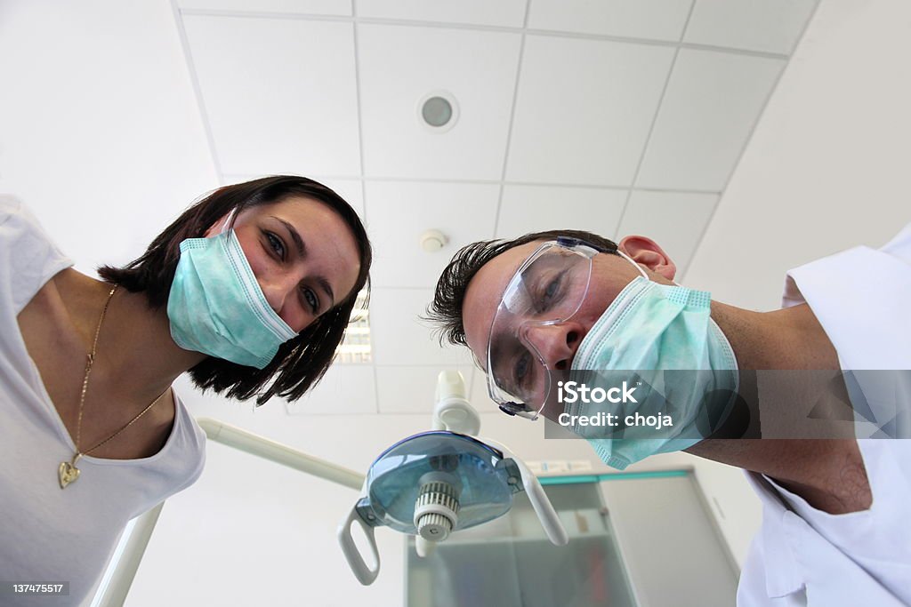 Dentista e il suo assistante sorridere alla macchina fotografica. - Foto stock royalty-free di Adulto