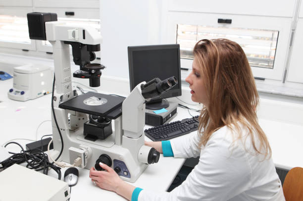 istock Young female researcher at the microscope 137477061