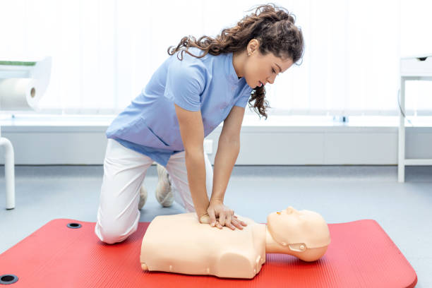 CPR class with instructors talking and demonstrating firt aid, compressions ans reanimation procedure. Cpr dummy