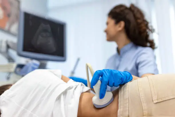 Photo of Doctor conducts ultrasound examination of patientv kidneys. Internal organs ultrasound concept. female's lower back diagnosis carried out with the use of an ultrasound