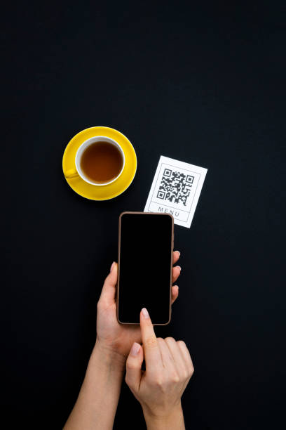 istock Top view Hand's customer scan QR code for online menu service at table in restaurant. New contactless technology lifestyle protection coronavirus pandemic in restaurant. 1374786798