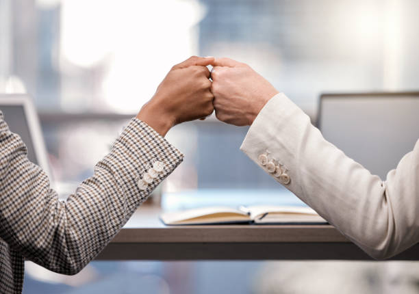 Shot of two businesswomen fist bumping one another