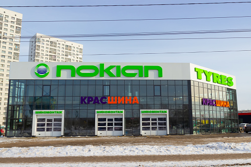 Krasnoyarsk, Russia - February 27, 2022: Nokian Tyres and KrasShina signs on the facade of the tire workshop building