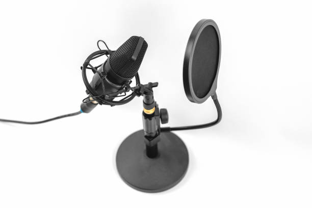 istock Close-up of a professional microphone with a pop filter in front of it. Desktop microphone for recording podcasts, songs and streaming on a stand against a light background 1374811939