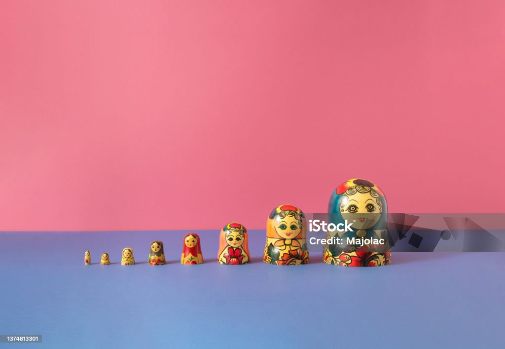 Russian dolls also known as matryoshka or babushka stacked on a pink and blue background. Minimal concept. Russian Nesting Doll Stock Photo