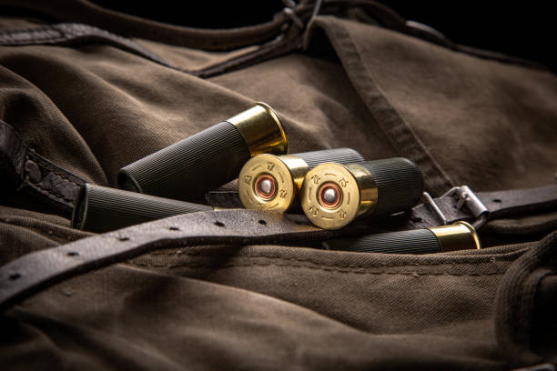 Shotgun shells close-up. Ammunition for smoothbore weapons on a khaki canvas backpack. Dark background.