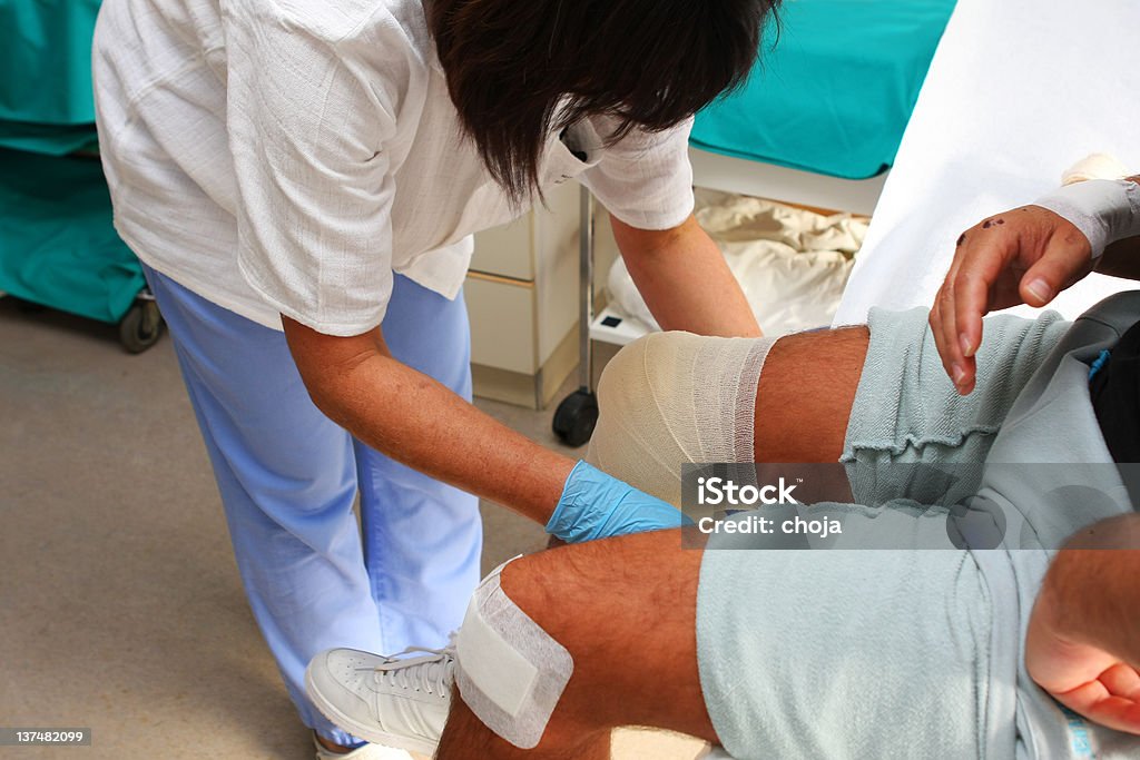 Infirmière prenant en charge les blessés genou, changer bandage - Photo de Appliquer libre de droits