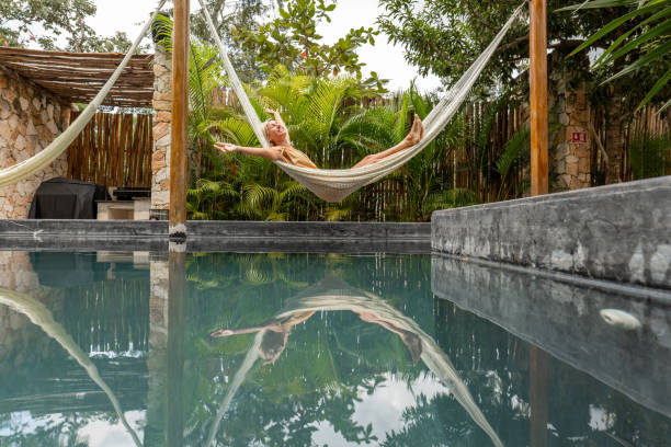 istock Woman relaxing in an hammock by the pool 1374824610