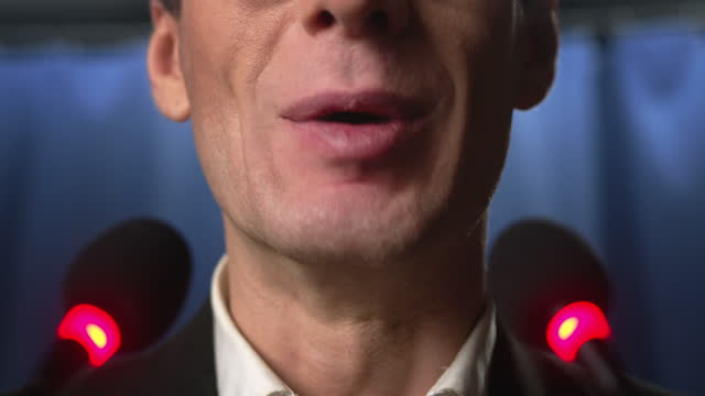 Close up of a microphone and a politician's mouth during the speech
