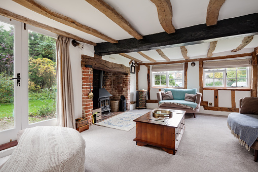 Historic 17th Century traditional furnished cottage living room with inglenook fireplace and exposed original timbers.
