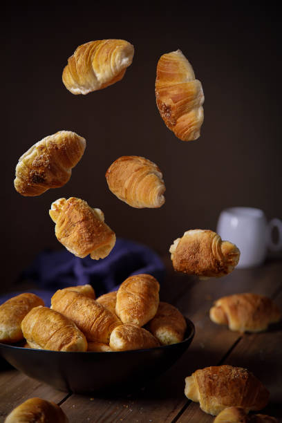 istock Fresh croissants fly into the plate in different positions. Levitation 1374832303