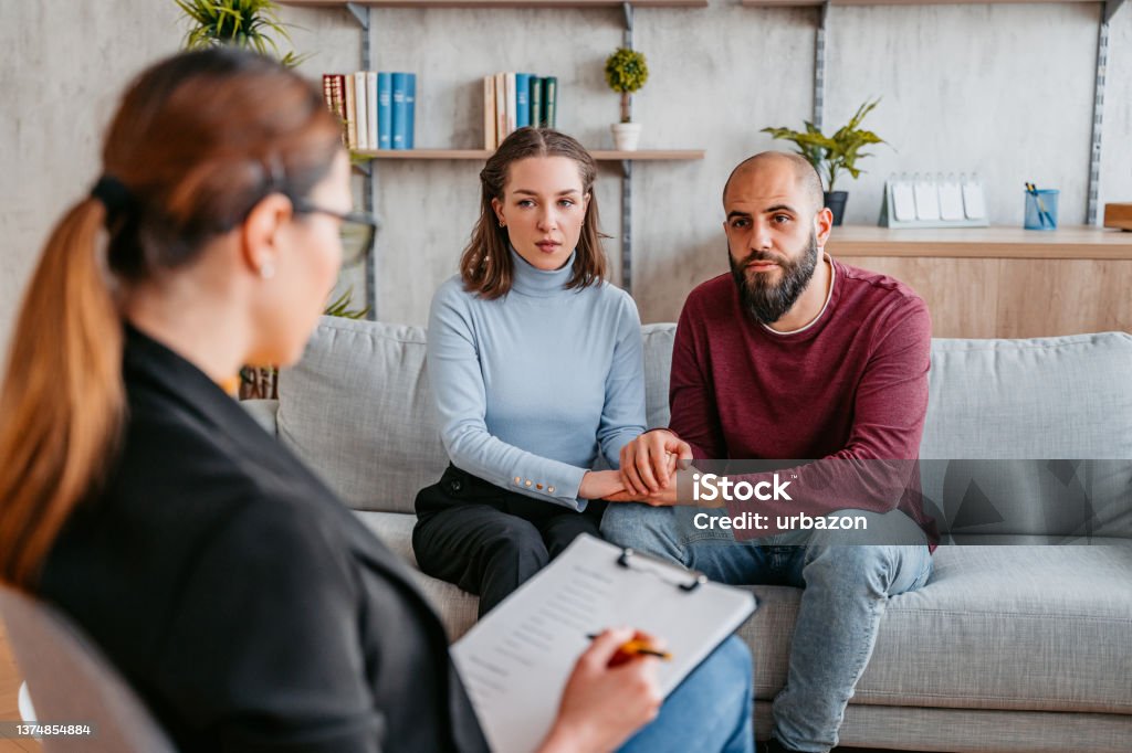 Young Couple Going To Marriage Counseling Young married couple having a marriage counseling session to fix the problems in their relationship. Psychotherapy Stock Photo