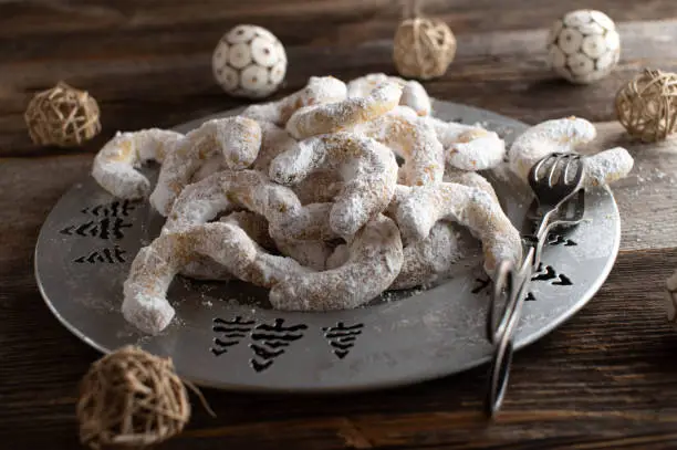 Traditional fresh and homemade baked vanillekipferl, german christmas cookies served on a silver plate on dark wooden table