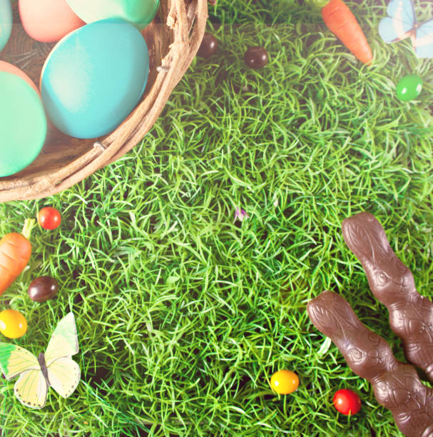 istock Easter colorful eggs, chocolate bunny, carrots candy in the grass. Top view. Copy space. 1374875895