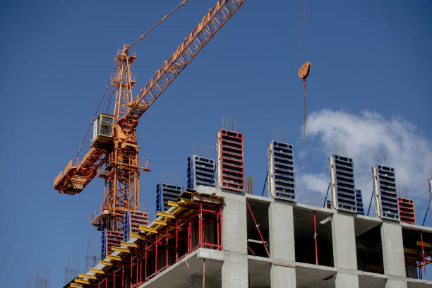istock Construction crane near the building under construction Crane. Self-erection crane near concrete building. Construction site. 1374876742