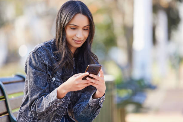 istock Shot of a beautiful young student using her phone while sitting outside 1374880175