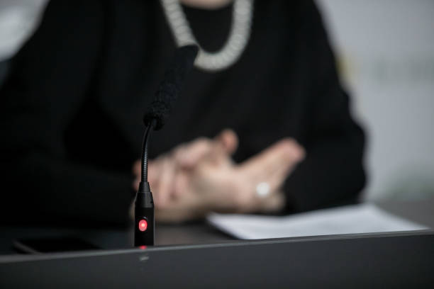 istock Microphone in seminar room, conference event or press conference Abstract blurred background. News conference. Political debate during answering media questions. 1374892048