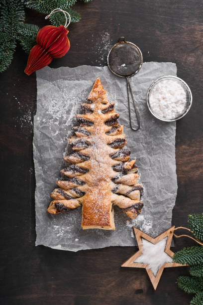 istock Puff pastry Christmas tree with chocolate paste, sprinkled with powdered sugar on old dark wooden background. Christmas or Xmas pastries. Top view. Copy Space 1374929533