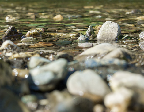 Stones and pebbles in shallow water with gentle wave action