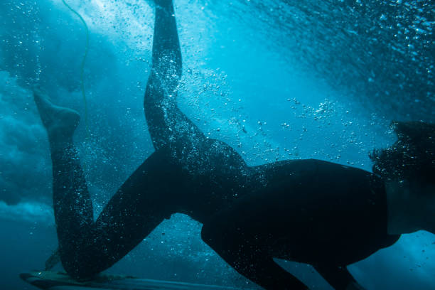 istock Underwater image of a surfer diving into a passing wave 1374950283