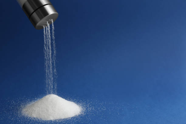 istock Pouring salt from shaker on blue background. Space for text 1374960613
