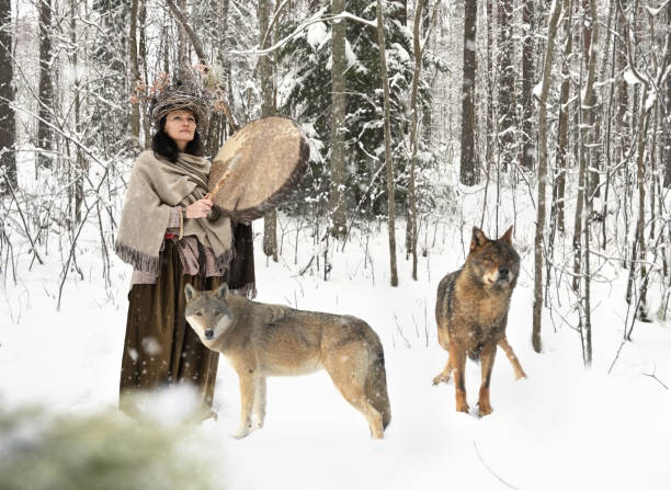 istock Shaman woman with wild wolves in a winter forest 1374965655